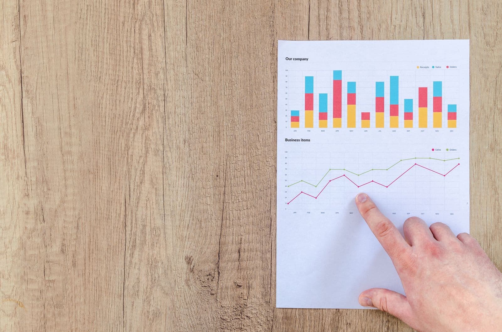 Main analysant des graphiques imprimés sur un bureau — l'examen des données d'un audit marketing